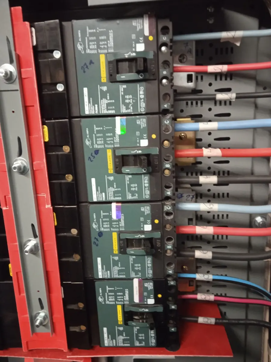 Banco de interruptores termomagnéticos con cableado identificado en un tablero