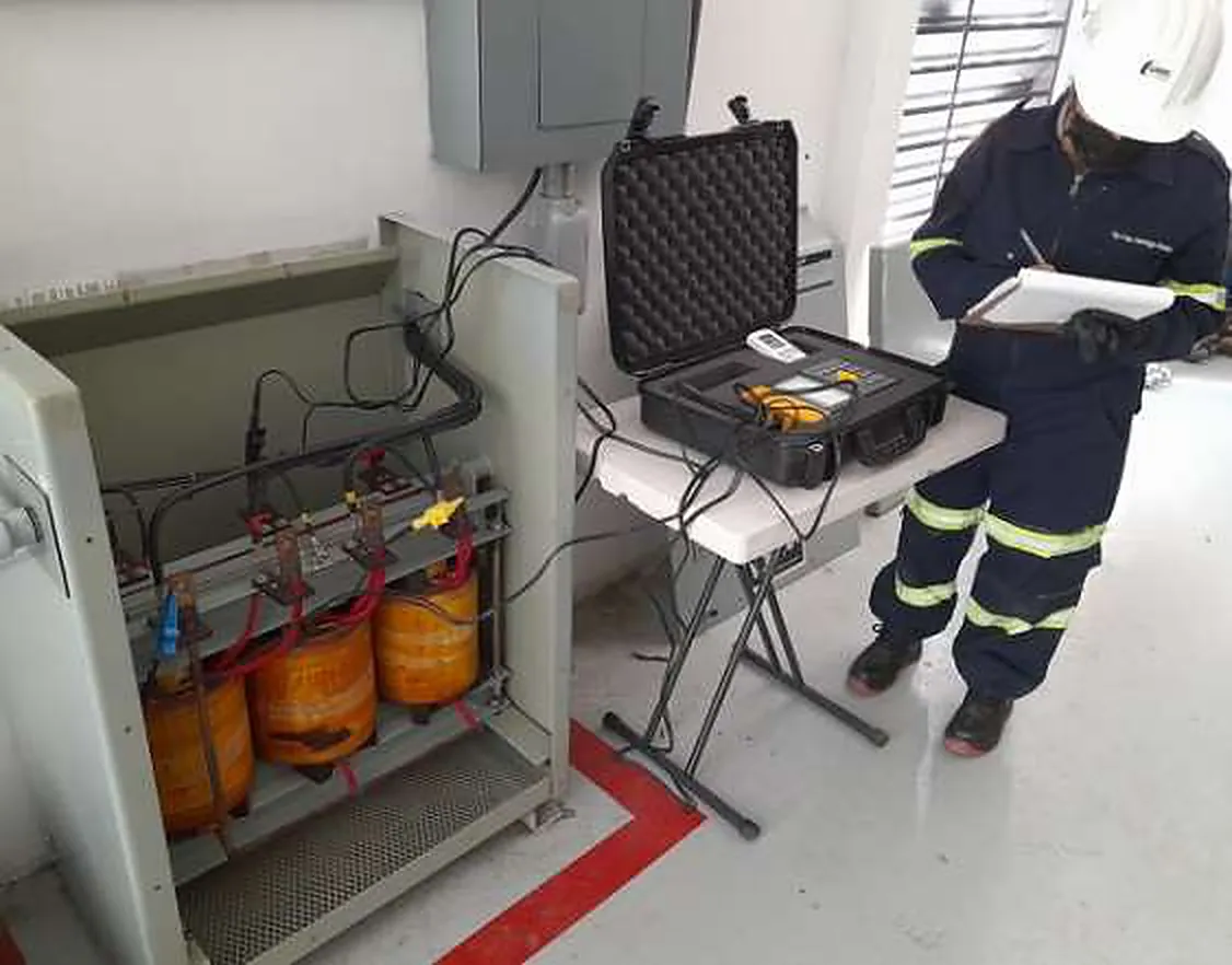 Técnico con equipo de pruebas junto a transformadores para medir la resistencia de devanados