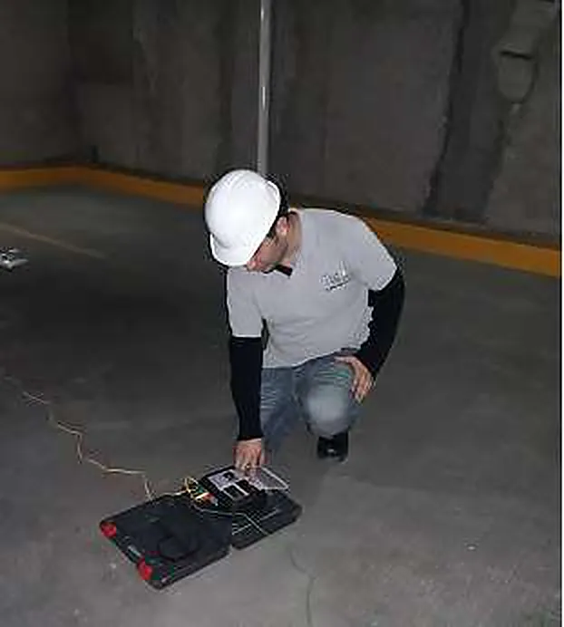 Técnico con casco midiendo la resistencia de puesta a tierra y la resistividad del terreno