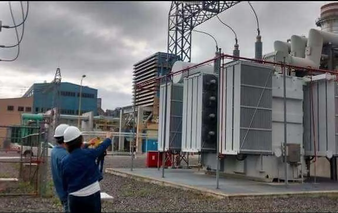 Ingenieros inspeccionando un transformador de potencia en una subestación eléctrica
